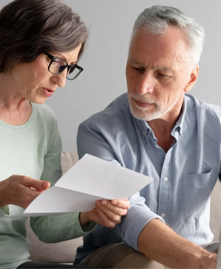 An elderly couple intently reviews a document together.